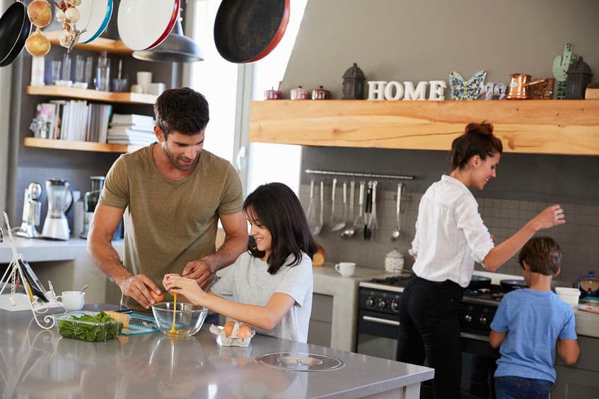 A parent and child cooking breakfast together in the kitchen